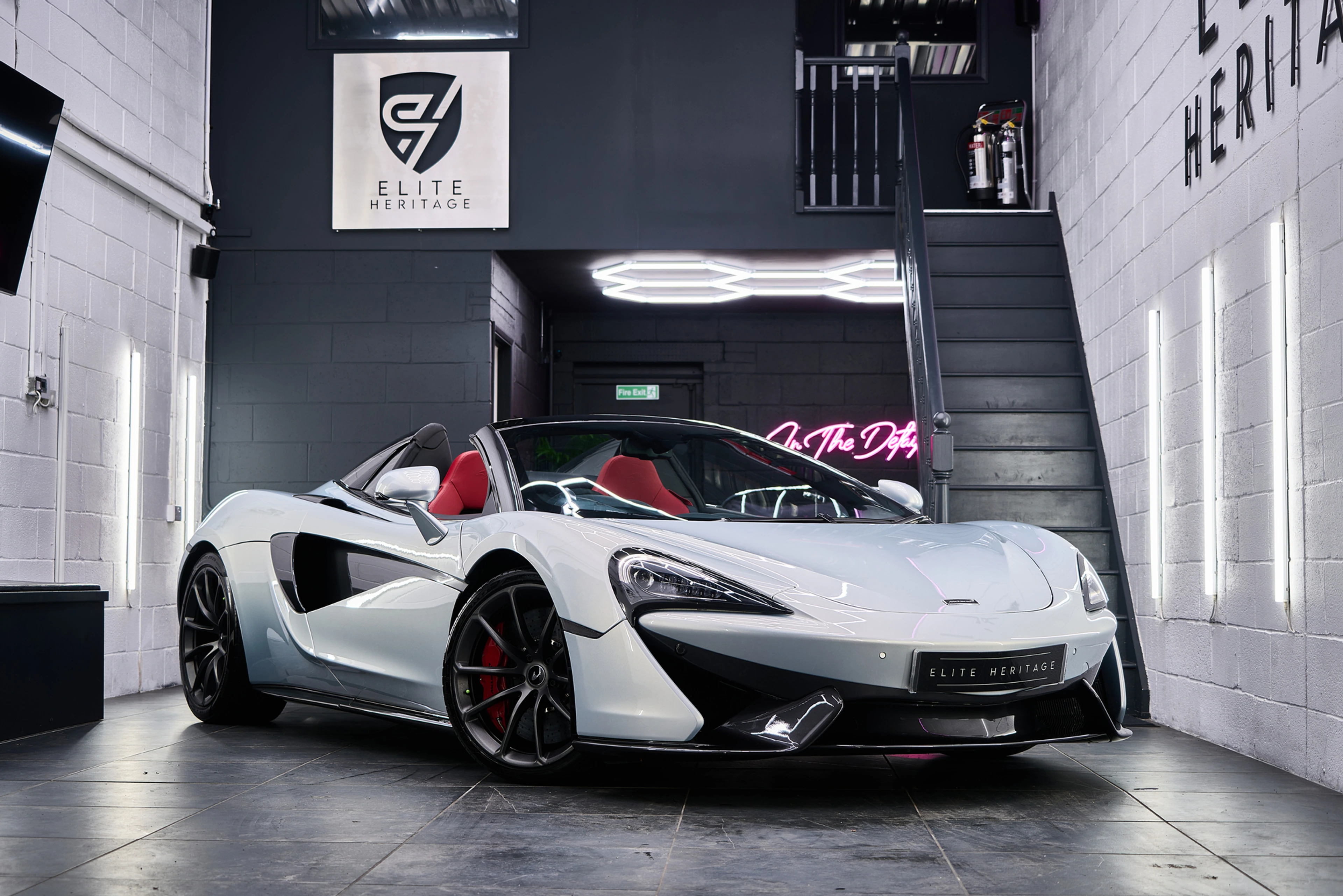 White McLaren 570S Spider with red interior presented in the Elite Heritage showroom